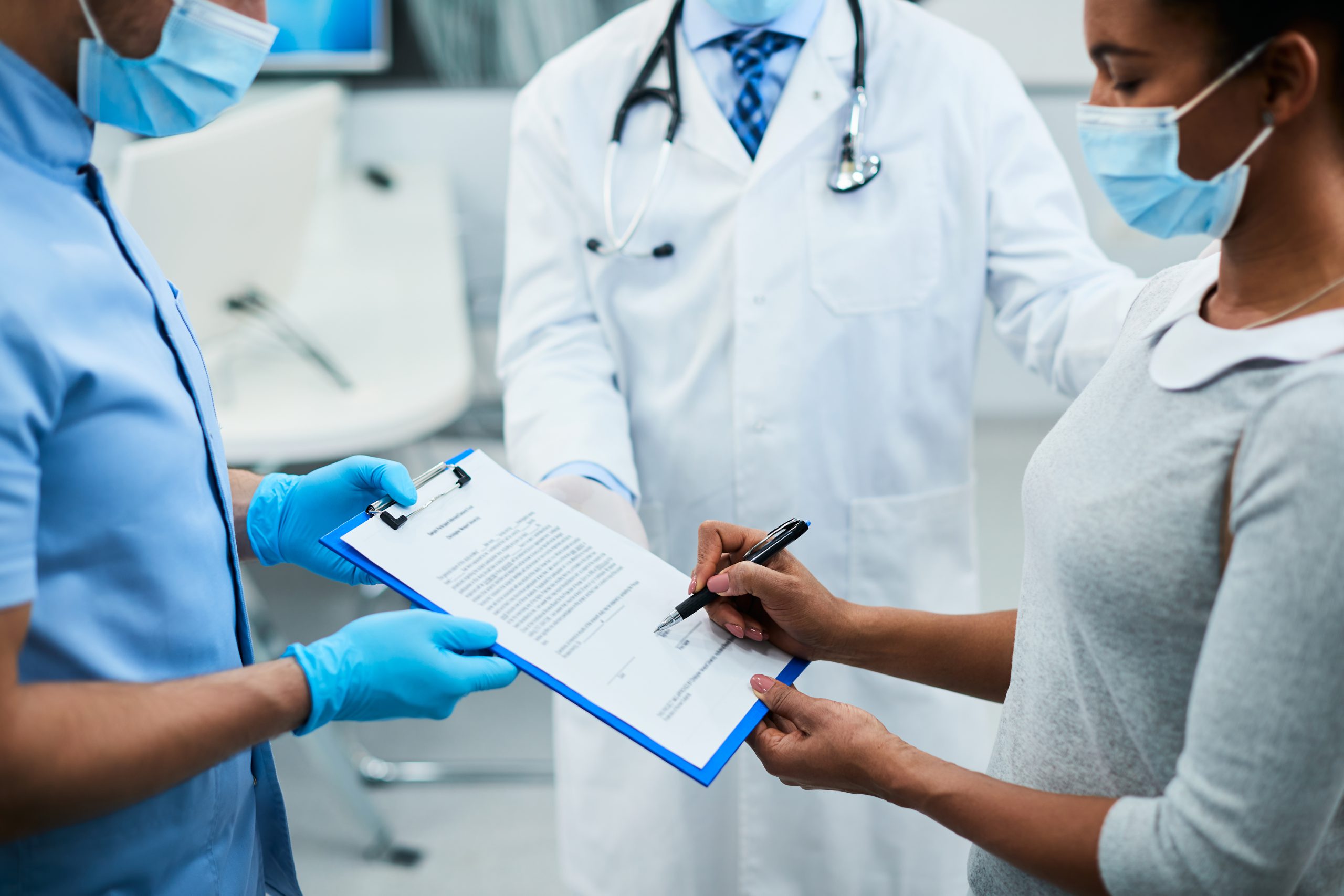 Patient and dentist signing paper for dental insurance