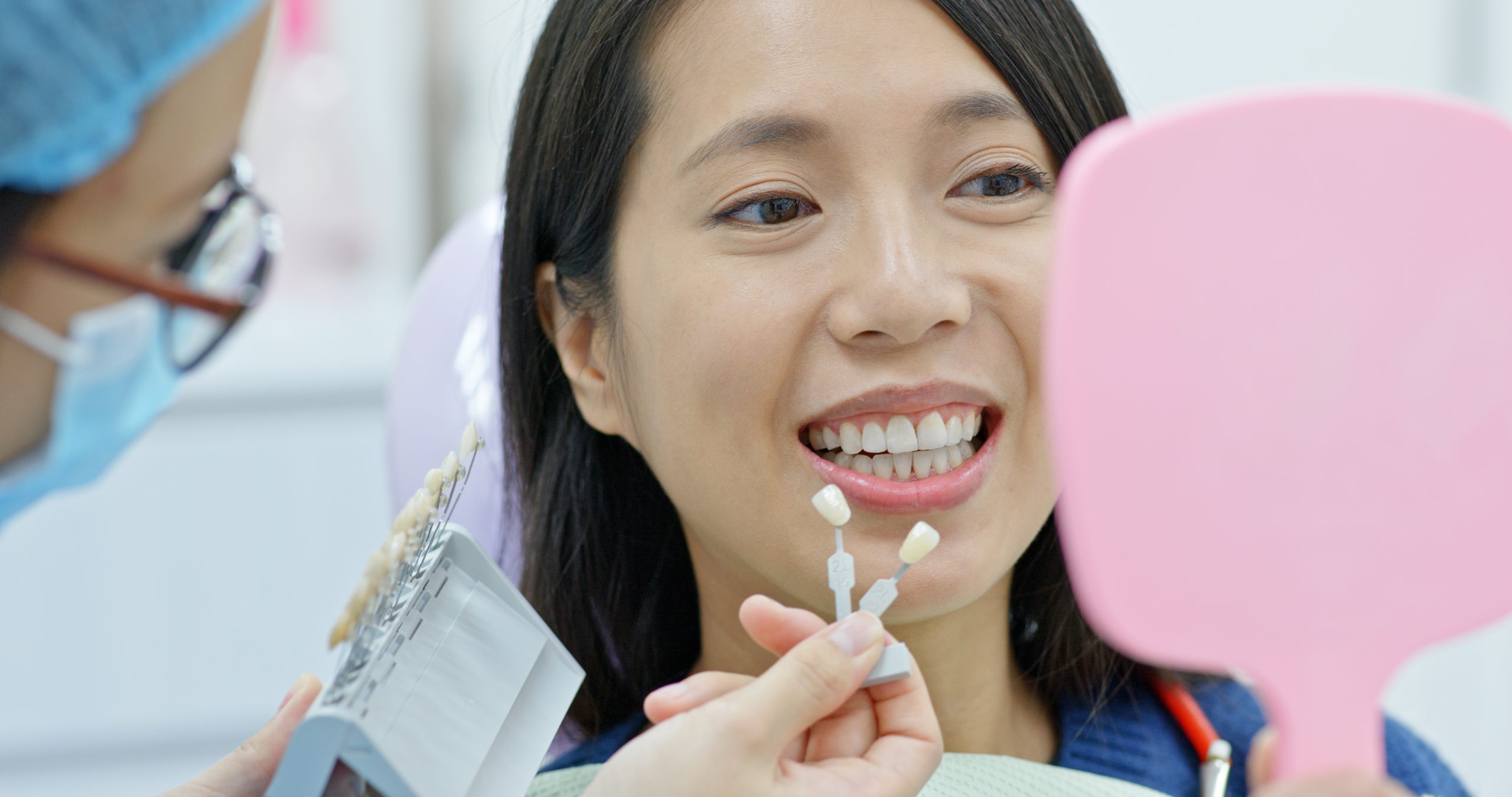Woman choosing color of her teeth
