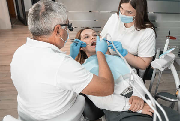 Female patient undergoing dental check-up with two professionals