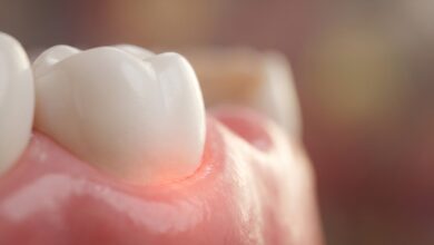 A detailed macro close-up image showing a clean white tooth meeting a healthy pink gum. The focus is on the gumline, symbolizing oral health and the early signs of gum disease.