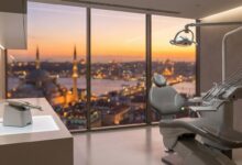 Una sala de clínica dental de última generación, vacía y limpia, con un sillón dental en primer plano y una vista panorámica y desenfocada de la silueta de Estambul a través de una gran ventana al amanecer.