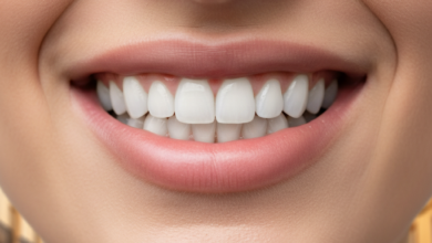Primer plano de una sonrisa radiante con dientes blancos y sanos, con un fondo difuminado de una calle o arquitectura española soleada.