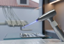 Una escena fotorealista que muestra un moderno instrumental láser dental con un haz de luz preciso, en un entorno de clínica estéril y futurista. El fondo, suavemente desenfocado, sugiere la arquitectura tradicional española bajo una iluminación tenue y avanzada, simbolizando la innovación dental en España.