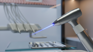 Una escena fotorealista que muestra un moderno instrumental láser dental con un haz de luz preciso, en un entorno de clínica estéril y futurista. El fondo, suavemente desenfocado, sugiere la arquitectura tradicional española bajo una iluminación tenue y avanzada, simbolizando la innovación dental en España.