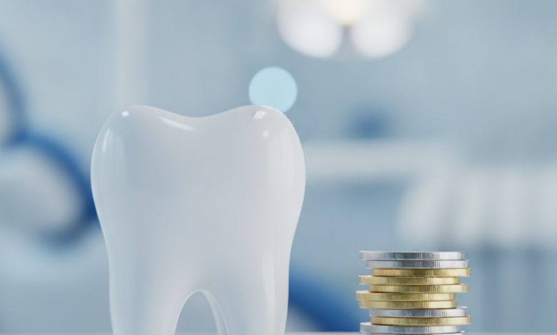 Primer plano de un diente molar blanco y saludable junto a una pila de monedas de oro y plata genéricas. El fondo está difuminado, mostrando el interior de una clínica dental moderna con iluminación suave.