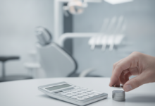 Una mano adulta coloca monedas sobre una superficie, con el fondo borroso de una clínica dental moderna y limpia, simbolizando la planificación financiera para tratamientos dentales en España.