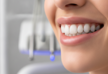 Primer plano fotorrealista de una sonrisa perfecta con dientes blancos y alineados, transmitiendo confianza y salud. El fondo borroso insinúa equipos dentales modernos en una clínica limpia.