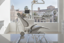Imagen fotorealista de un interior de clínica dental moderno y luminoso con instrumental estéril en primer plano. A través de la ventana, se ve una vista borrosa de la ciudad de Málaga bajo un sol brillante.