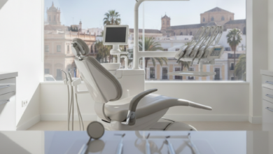 Imagen fotorealista de un interior de clínica dental moderno y luminoso con instrumental estéril en primer plano. A través de la ventana, se ve una vista borrosa de la ciudad de Málaga bajo un sol brillante.
