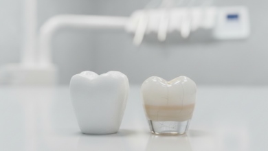Una imagen fotorealista de primer plano que muestra dos coronas dentales lado a lado. A la izquierda, una corona de color blanco opaco que simboliza la fuerza del zirconio. A la derecha, una corona translúcida y estratificada que representa la estética de la porcelana. Ambas están sobre una superficie limpia con un fondo borroso de un laboratorio dental.